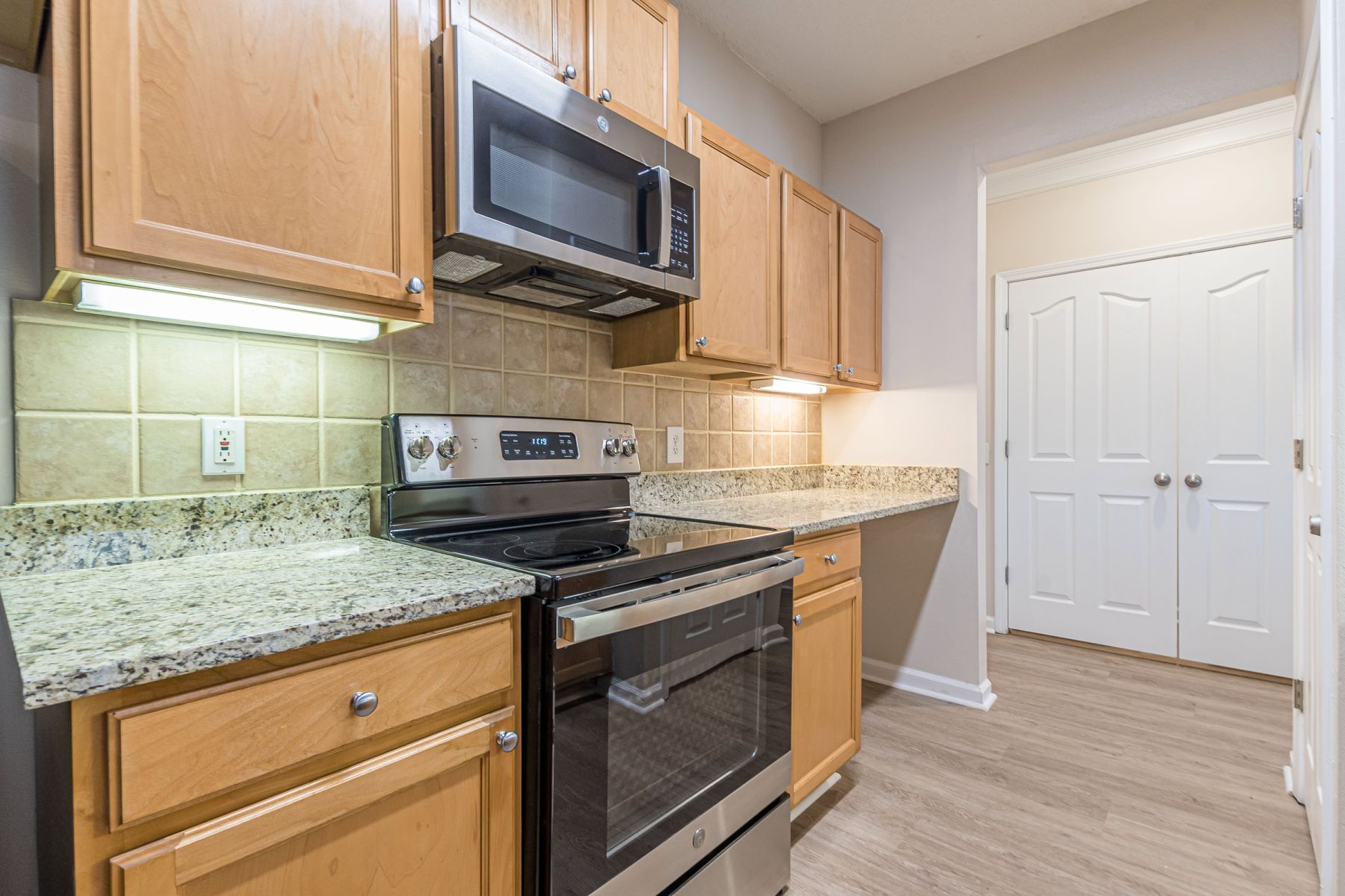 Luxury apartment kitchen with stainless steel appliances, granite countertops, and lots of storage space